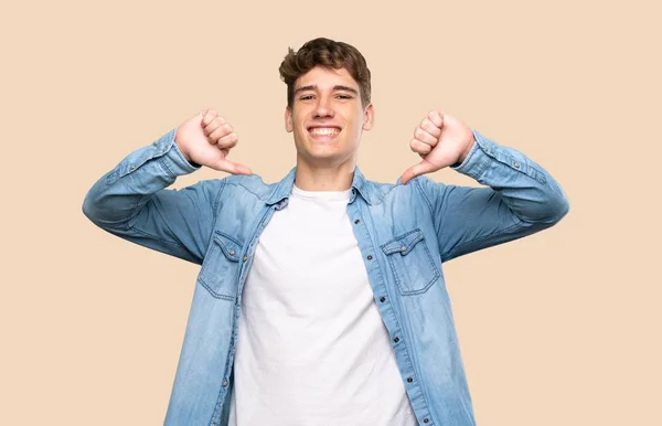 Bonito Jovem Mostrando Polegar Para Baixo Sobre Fundo Isolado — Fotografia de Stock