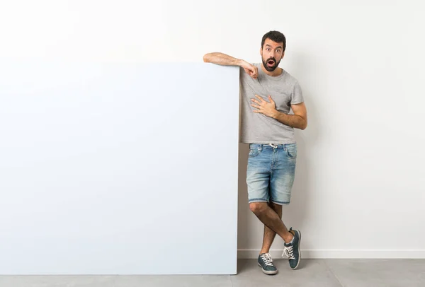 Jovem Homem Bonito Com Barba Segurando Grande Cartaz Azul Vazio — Fotografia de Stock