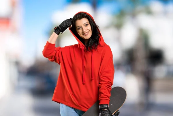 Mulher skatista jovem com camisola vermelha — Fotografia de Stock