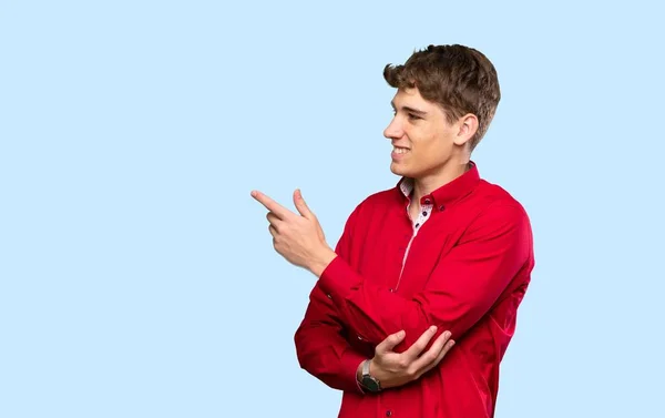 Stilig Ung Man Pekar Finger Sidan Över Isolerad Blå Bakgrund — Stockfoto