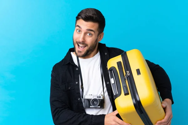 Utazó Férfi Kezében Egy Bőrönd Felett Elszigetelt Kék Háttér Boldog — Stock Fotó
