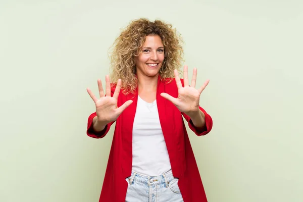 Junge Blonde Frau Mit Lockigem Haar Über Isoliertem Grünem Hintergrund — Stockfoto