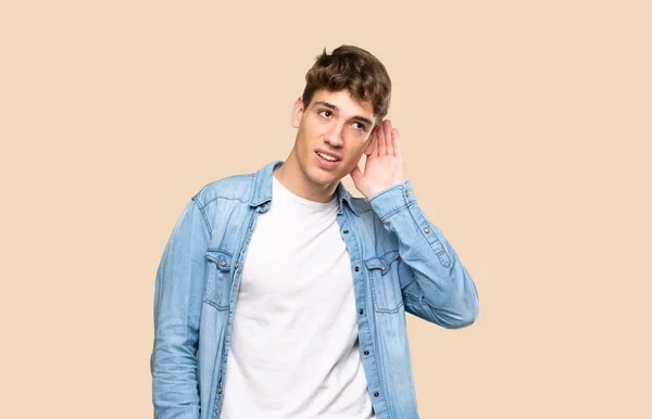 Pohledný Mladý Muž Který Něco Poslouchá Tím Položí Ruku Ucho — Stock fotografie