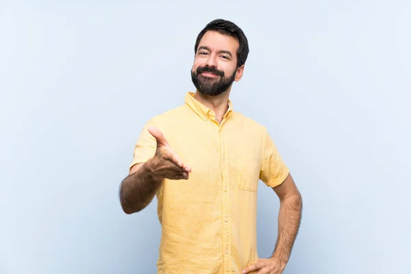 Jeune Homme Avec Barbe Sur Fond Bleu Isolé Serrant Main — Photo