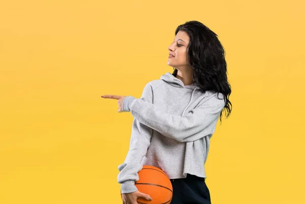 Mujer Joven Jugando Baloncesto Apuntando Hacia Lado Para Presentar Producto —  Fotos de Stock