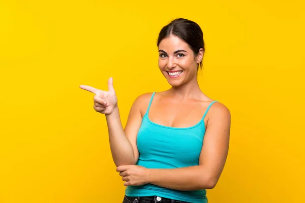 Junge Frau Auf Gelbem Hintergrund Zeigt Mit Dem Finger Zur — Stockfoto