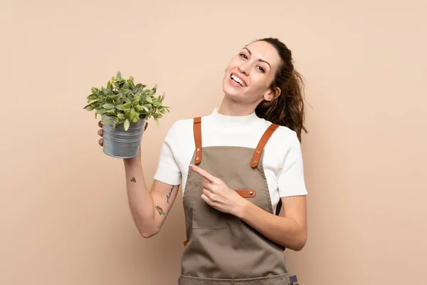 Mujer Jardinero Sosteniendo Una Planta Señalándola —  Fotos de Stock