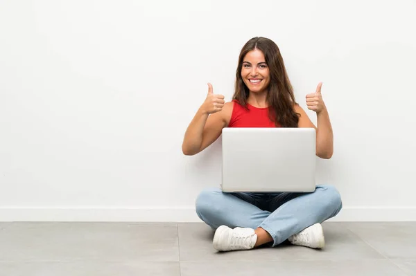 Dizüstü Bilgisayarı Olan Genç Bir Kadın Yerde Oturuyor Baş Parmak — Stok fotoğraf