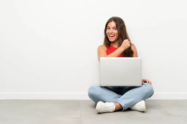 Junge Frau Mit Laptop Sitzt Auf Dem Boden Und Feiert — Stockfoto