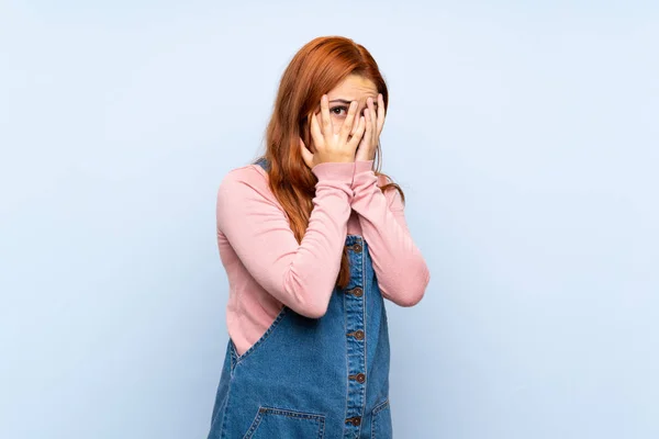 Menina Ruiva Adolescente Com Macacão Sobre Fundo Azul Isolado Cobrindo — Fotografia de Stock