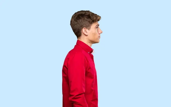 Stilig Ung Man Tittar Sidan Över Isolerad Blå Bakgrund — Stockfoto