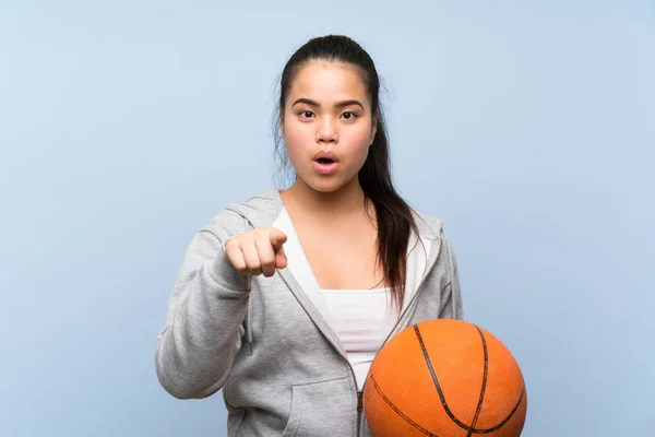 Jong Aziatisch Meisje Spelen Basketbal Geïsoleerde Achtergrond Verrast Wijzen Naar — Stockfoto