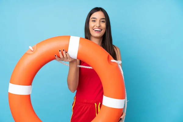 Lifeguard woman over isolated blue background with lifeguard equipment and with happy expression