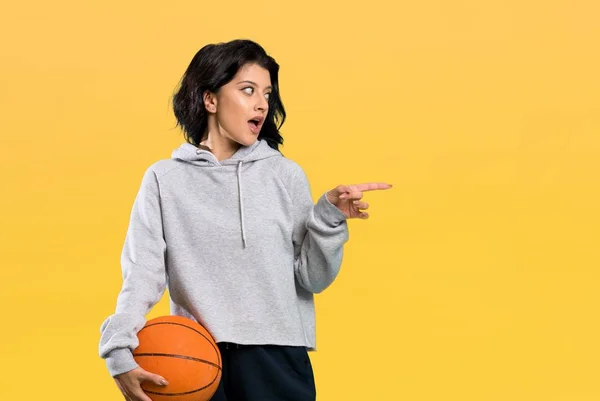 Young Woman Playing Basketball Surprised Pointing Finger Side Isolated Background — ストック写真