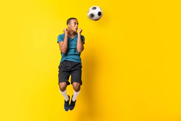 Afro-americano jogador de futebol homem sobre isolado amarelo backgroun — Fotografia de Stock
