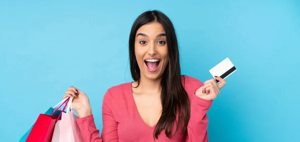 Jonge Brunette Vrouw Geïsoleerde Blauwe Achtergrond Holding Shopping Tassen Verrast — Stockfoto