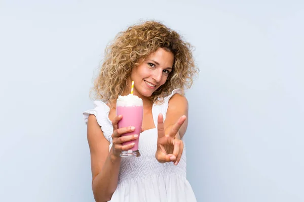Young Blonde Woman Curly Hair Holding Strawberry Milkshake Smiling Showing — 스톡 사진