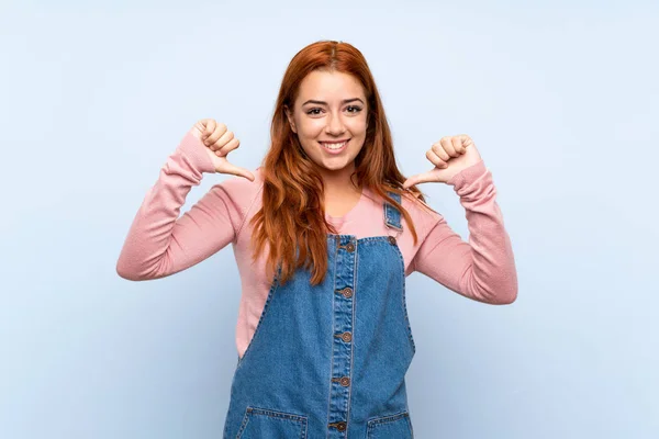 Teenager Redhead Girl Overalls Isolated Blue Background Proud Self Satisfied — 스톡 사진