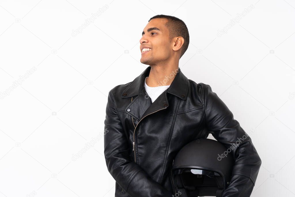 Young handsome man with a motorcycle helmet over isolated white background looking to the side
