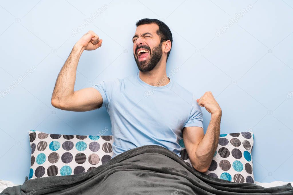 Man in bed celebrating a victory