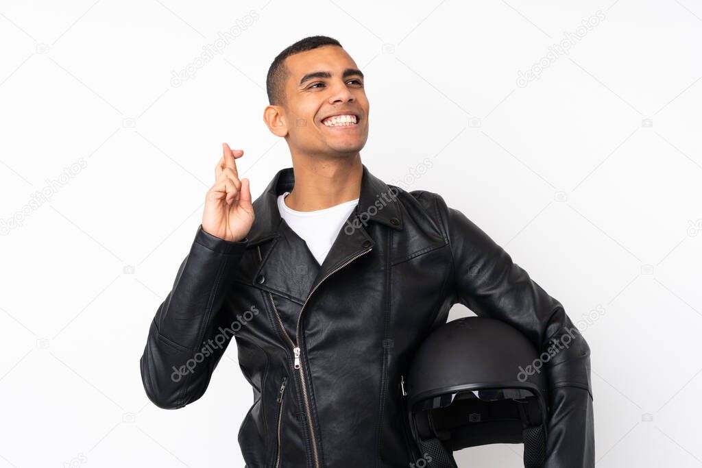 Young handsome man with a motorcycle helmet over isolated white background with fingers crossing