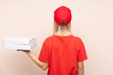 İzole edilmiş duvarın arkasında pizza tutan Rus kadın.