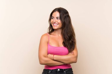 Genç kadın soyutlanmış beyaz arka planda mutlu ve gülümsüyor.