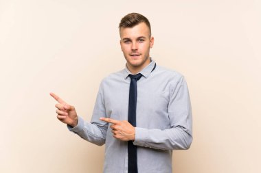 Izole arka plan tarafında parmak işaret üzerinde Genç sarışın işadamı
