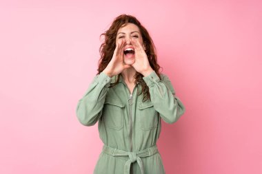 Pembe arka planda genç ve güzel bir kadın bağırıyor ve bir şeyler söylüyor.