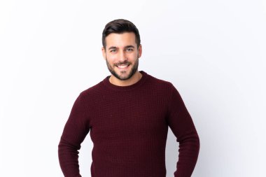 Sakallı, yakışıklı, soyutlanmış beyaz arka planda gülen genç bir adam.