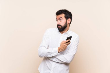 Sakallı genç adam omuzlarını kaldırırken şüpheli hareketler yapıyor.