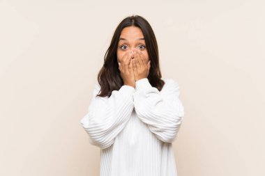 Sürpriz yüz ifadesi ile izole arka plan üzerinde beyaz kazak ile genç esmer kadın