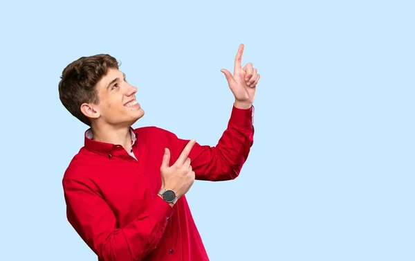 Yakışıklı Genç Adam Işaret Parmağıyla Işaret Ediyor Zole Edilmiş Mavi — Stok fotoğraf