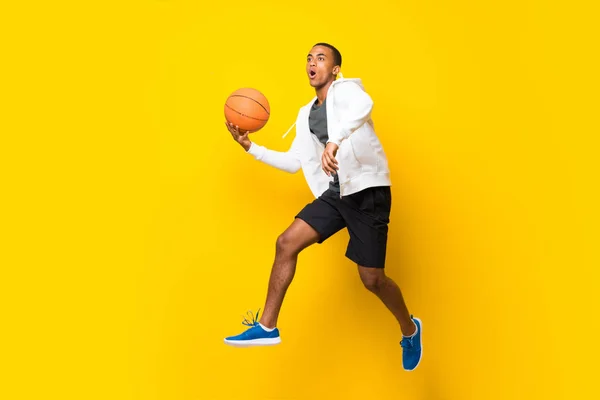 Afro-americano jogador de basquete homem sobre isolado backgro amarelo — Fotografia de Stock