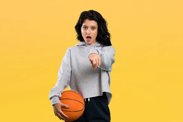 Giovane Donna Che Gioca Basket Sorpreso Indicando Anteriore Sfondo Isolato — Foto Stock