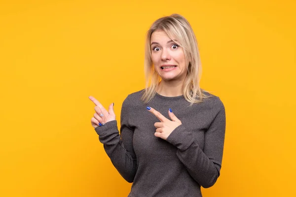 Giovane Donna Bionda Sfondo Giallo Isolato Spaventato Indicando Lato — Foto Stock