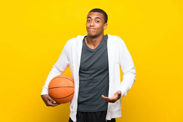 African American basketball player man making doubts gesture while lifting the shoulders