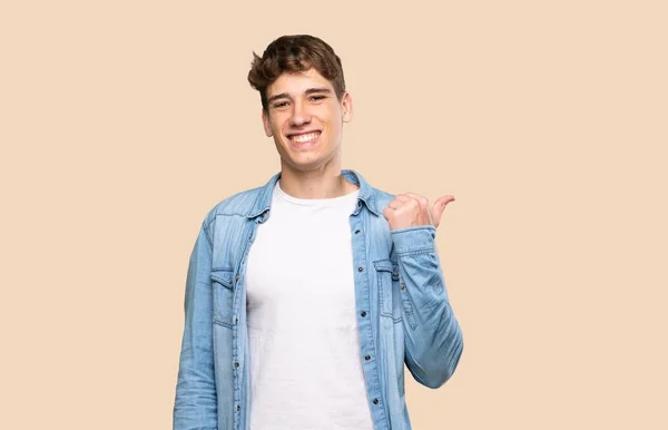 Hezký Mladý Muž Ukazuje Stranu Prezentovat Produkt Přes Izolované Pozadí — Stock fotografie