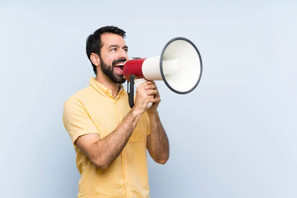 Jongeman Met Baard Geïsoleerde Blauwe Achtergrond Schreeuwend Door Een Megafoon — Stockfoto