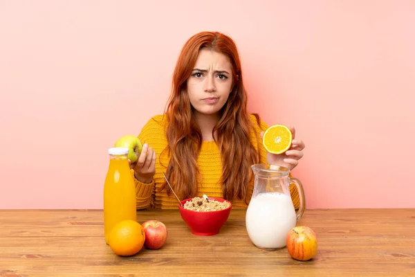 Teenager rotschopf mädchen having breakfast im ein tabelle und having doubt — Stockfoto