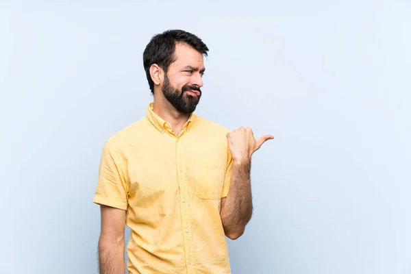 Jeune Homme Avec Barbe Sur Fond Bleu Isolé Malheureux Pointant — Photo