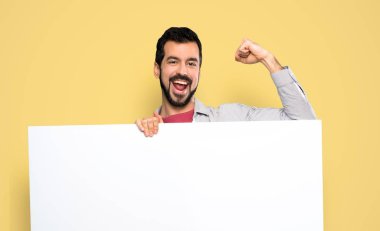 Boş bir afiş tutarak sakallı yakışıklı adam