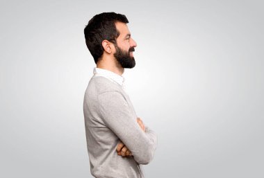 Handsome man in lateral position over isolated grey background