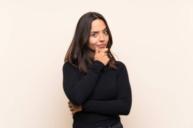 Young brunette woman with white sweater over isolated background thinking