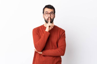 Sakallı, beyaz arka planda beyaz tenli beyaz bir adam sessiz bir jest işareti gösteriyor. Parmağını ağzına sokuyor.