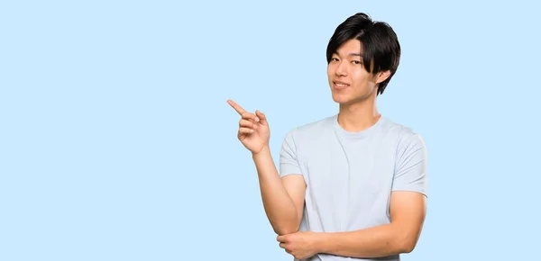 Asian Man Blue Shirt Pointing Finger Side Isolated Blue Background — Stock Photo, Image