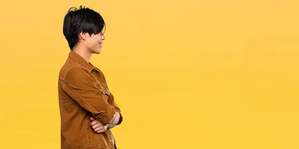 Asiatischer Mann Mit Brauner Jacke Seitenlage Über Isoliertem Gelben Hintergrund — Stockfoto