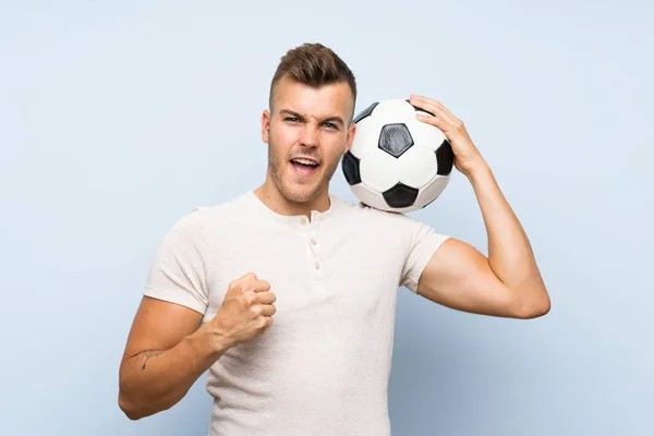 Jonge Knappe Blonde Man Geïsoleerde Blauwe Achtergrond Houden Een Voetbal — Stockfoto