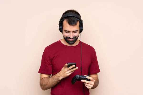 Homem Jogando Com Controlador Videogame Sobre Parede Isolada Enviando Uma — Fotografia de Stock
