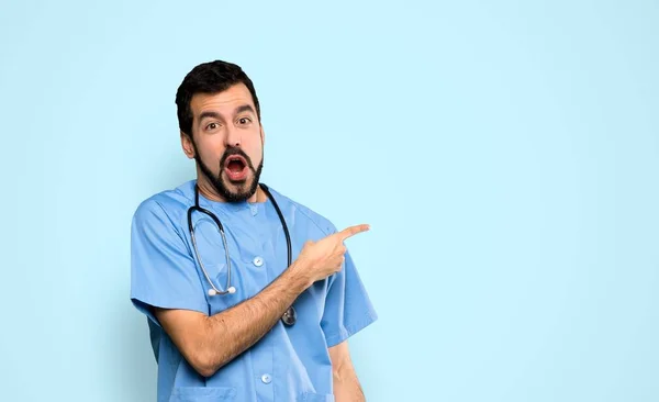 Surgeon Doctor Man Surprised Pointing Side Isolated Blue Background — Stock Photo, Image